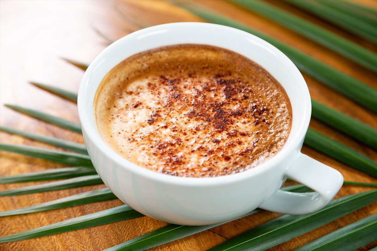 A cup of coffee on a palm leaf at a café in Maui.